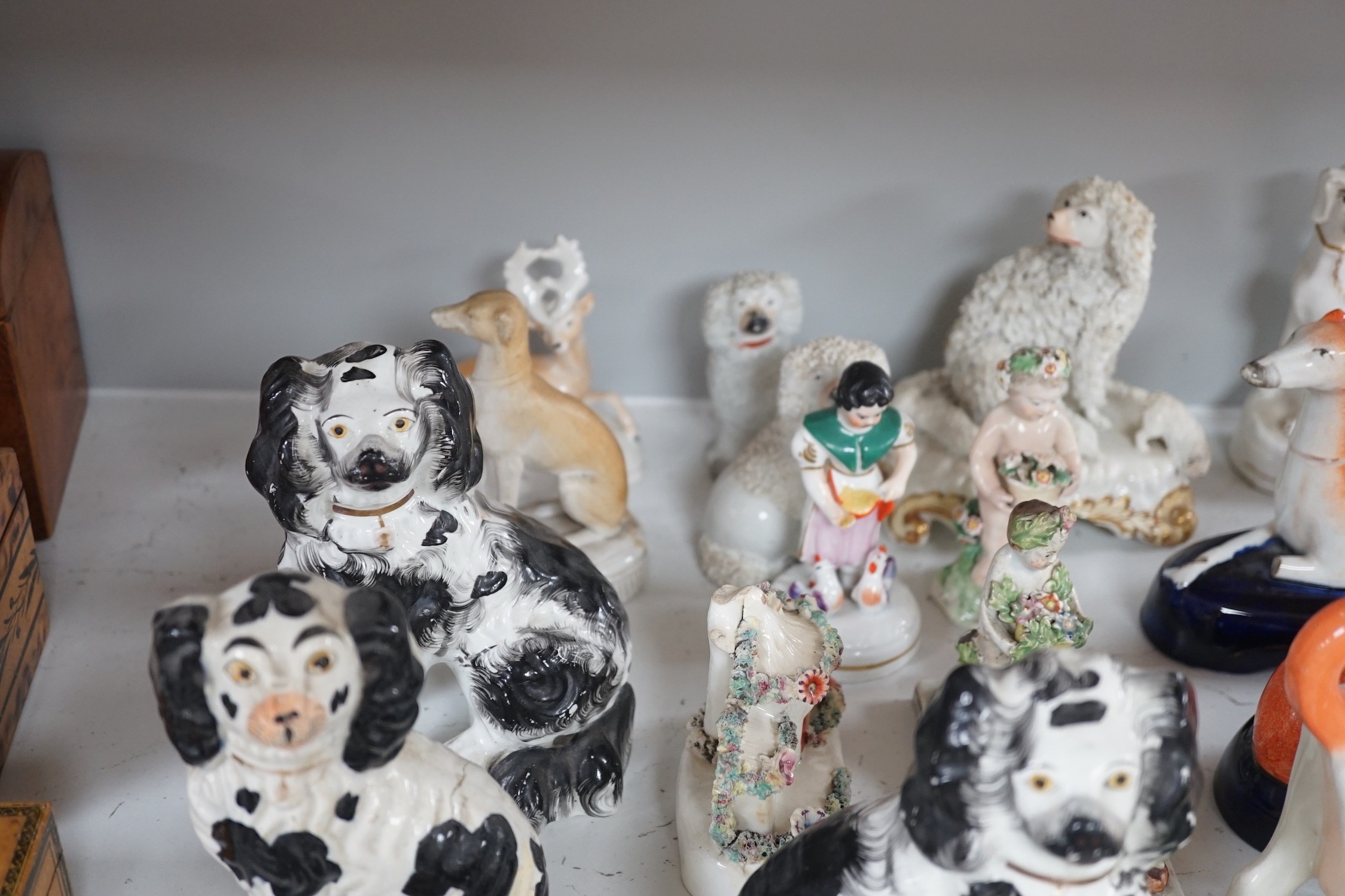 A quantity of Victorian Staffordshire animal figures, two pearlware putti and a Derby figure of a cherub, tallest 14.5 cm